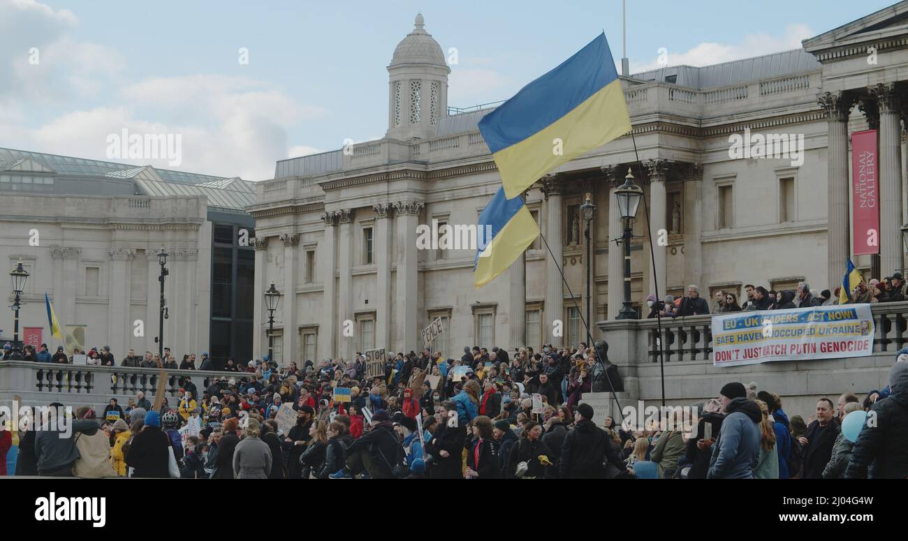 London, UK - 03 06 2022:  A crowd of people at a protest on Trafalgar Square, with blue and yellow Ukrainian flags blowing in the wind. Stock Photo