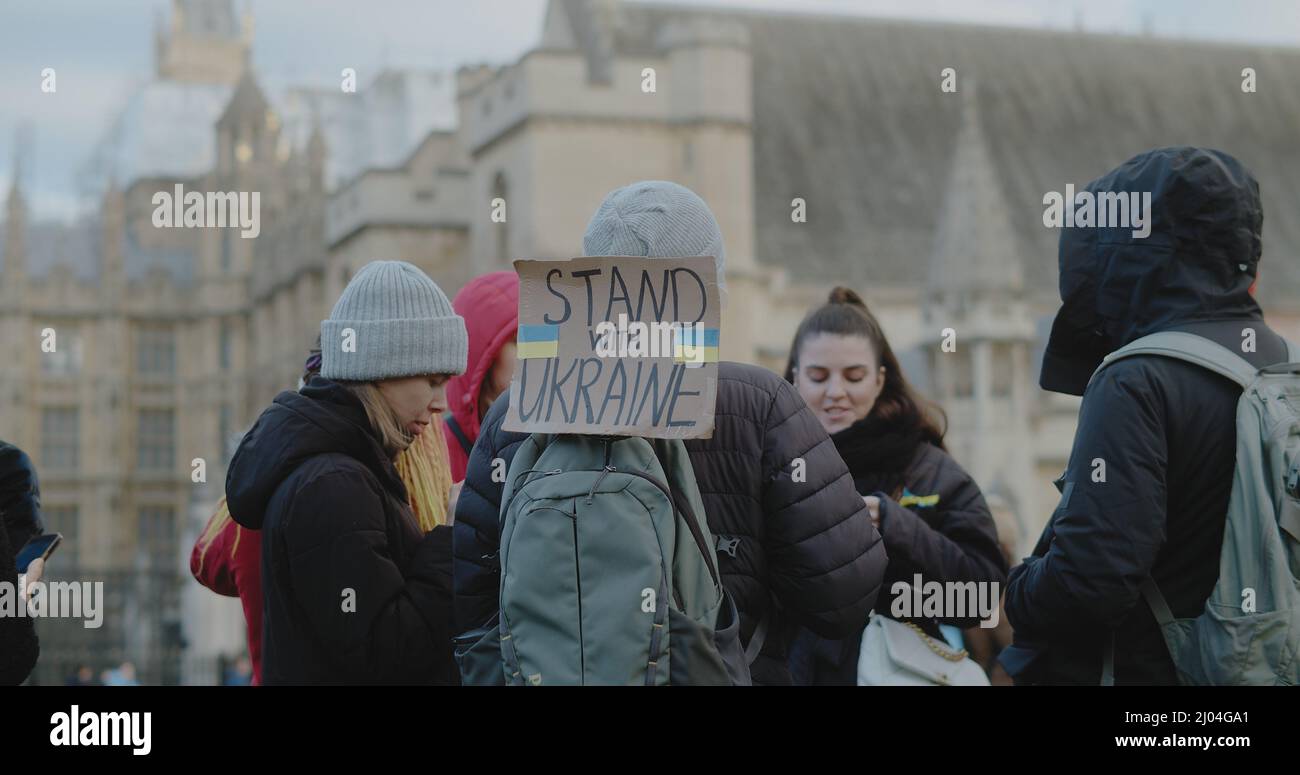 London, UK - 03 06 2022:  A protester on Parliament Square in Westminster, with a sign coming out from his backpack, ‘Stand With Ukraine’. Stock Photo