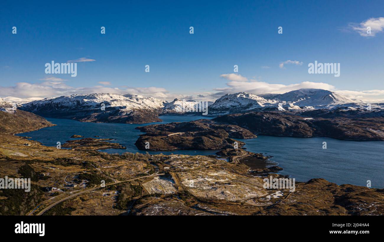 Aerial view of Kylesku Bridge, Loch a Chain Bhain, with snow covered Assynt in the background, Highland, Scotland. Stock Photo
