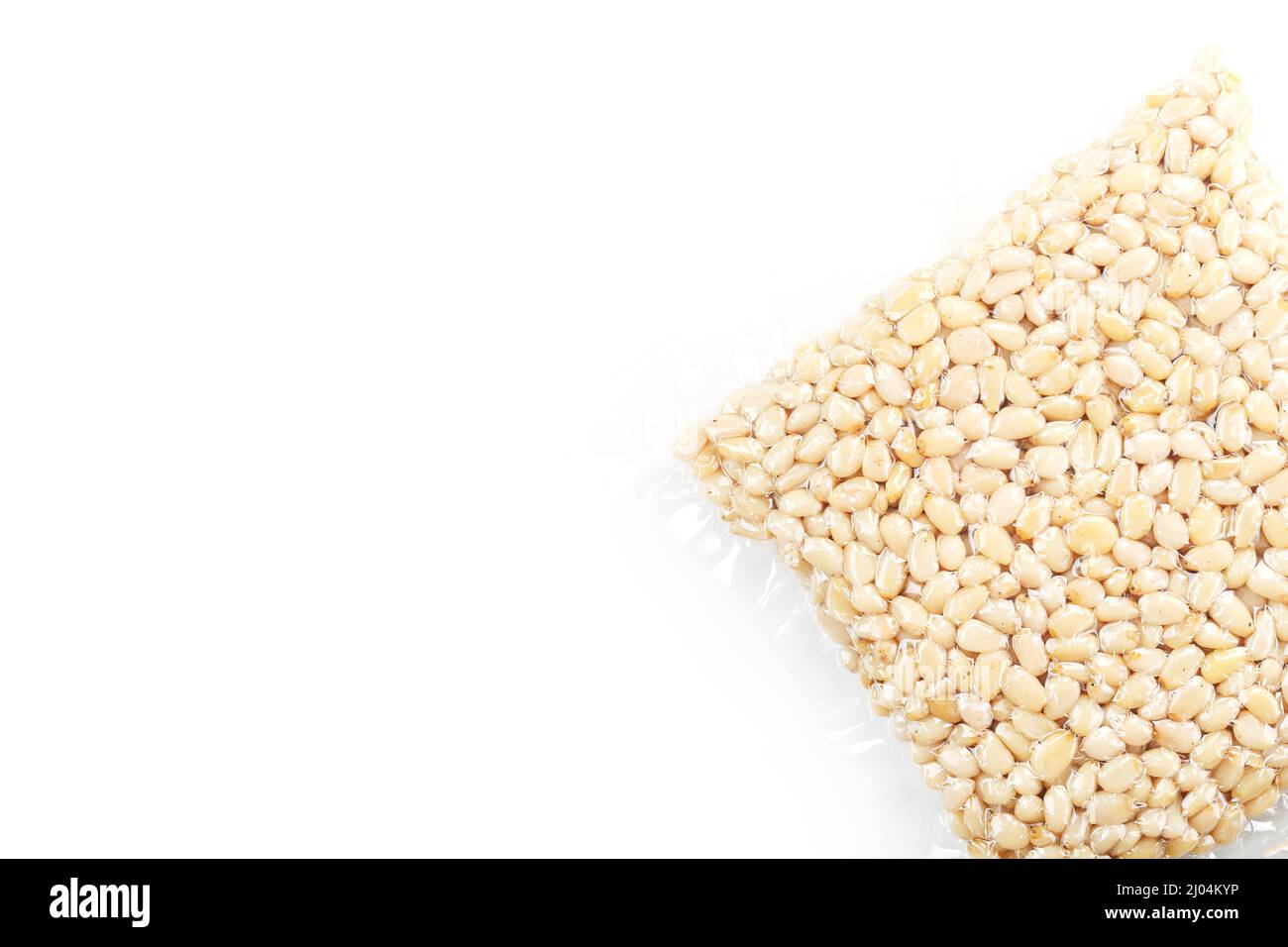 Pine nuts in a transparent vacuum package over a white background Stock Photo