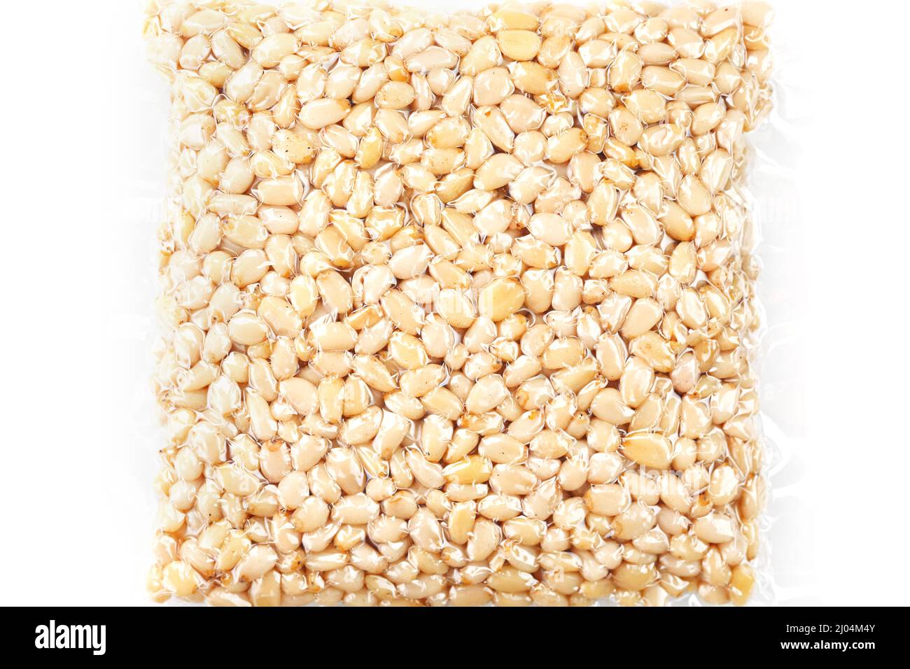 Pine nuts in a transparent vacuum package over a white background Stock Photo