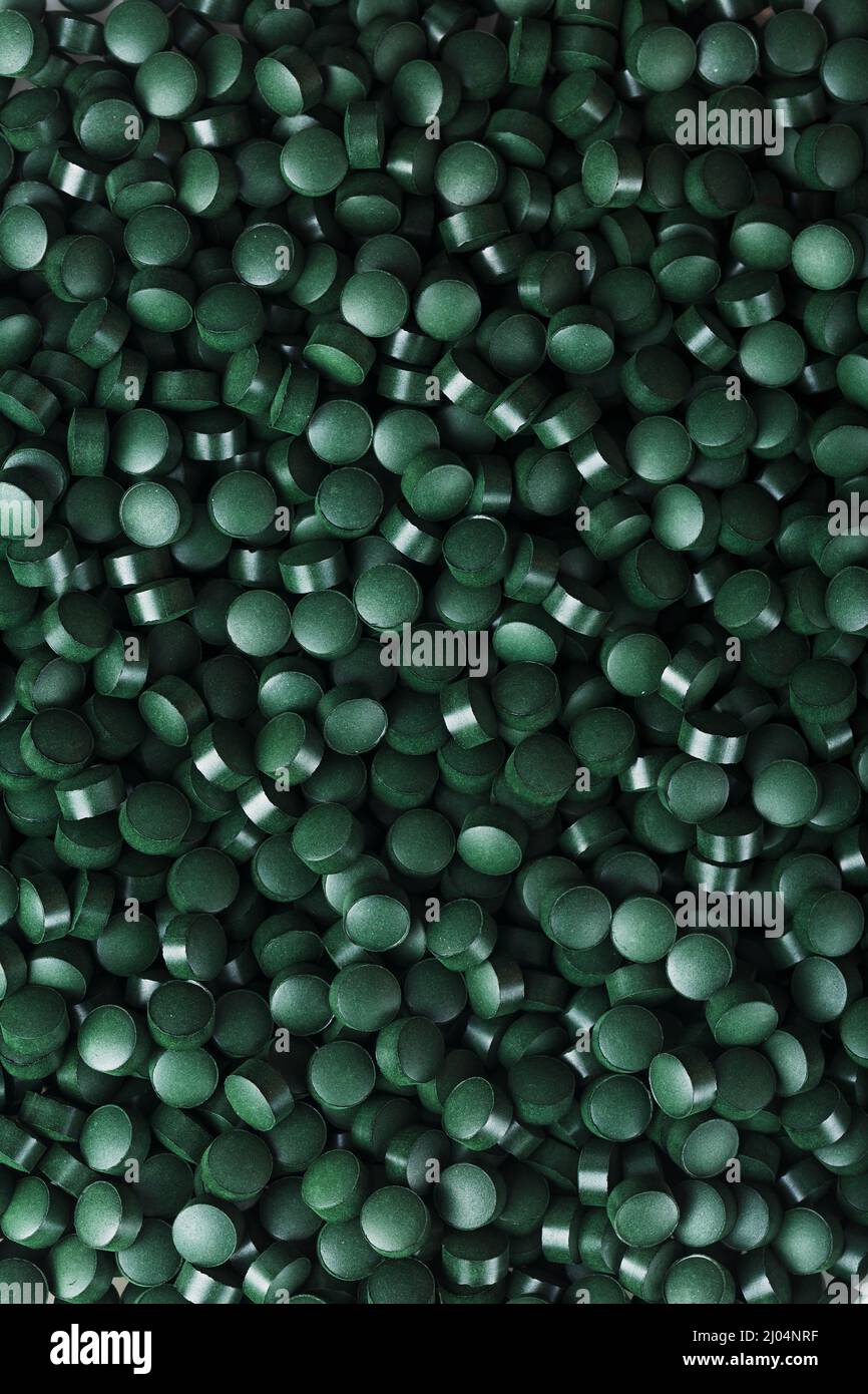 Dark Green round tablets of organic spirulina as a texture background in  full screen Stock Photo - Alamy