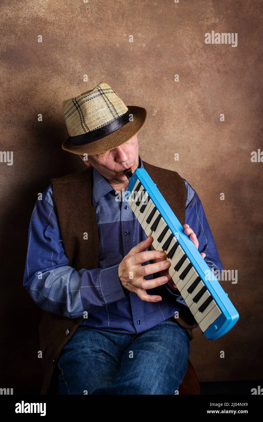 adult man playing the melodica Stock Photo