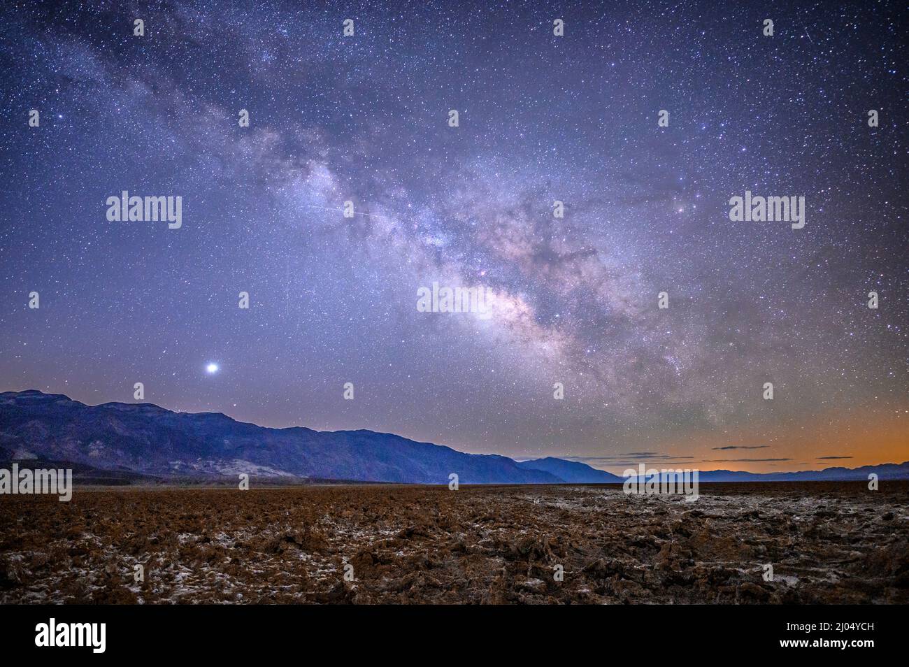 Milky Way over Badwater Basin and the Black Mountains, Death Valley National Park, California. Stock Photo