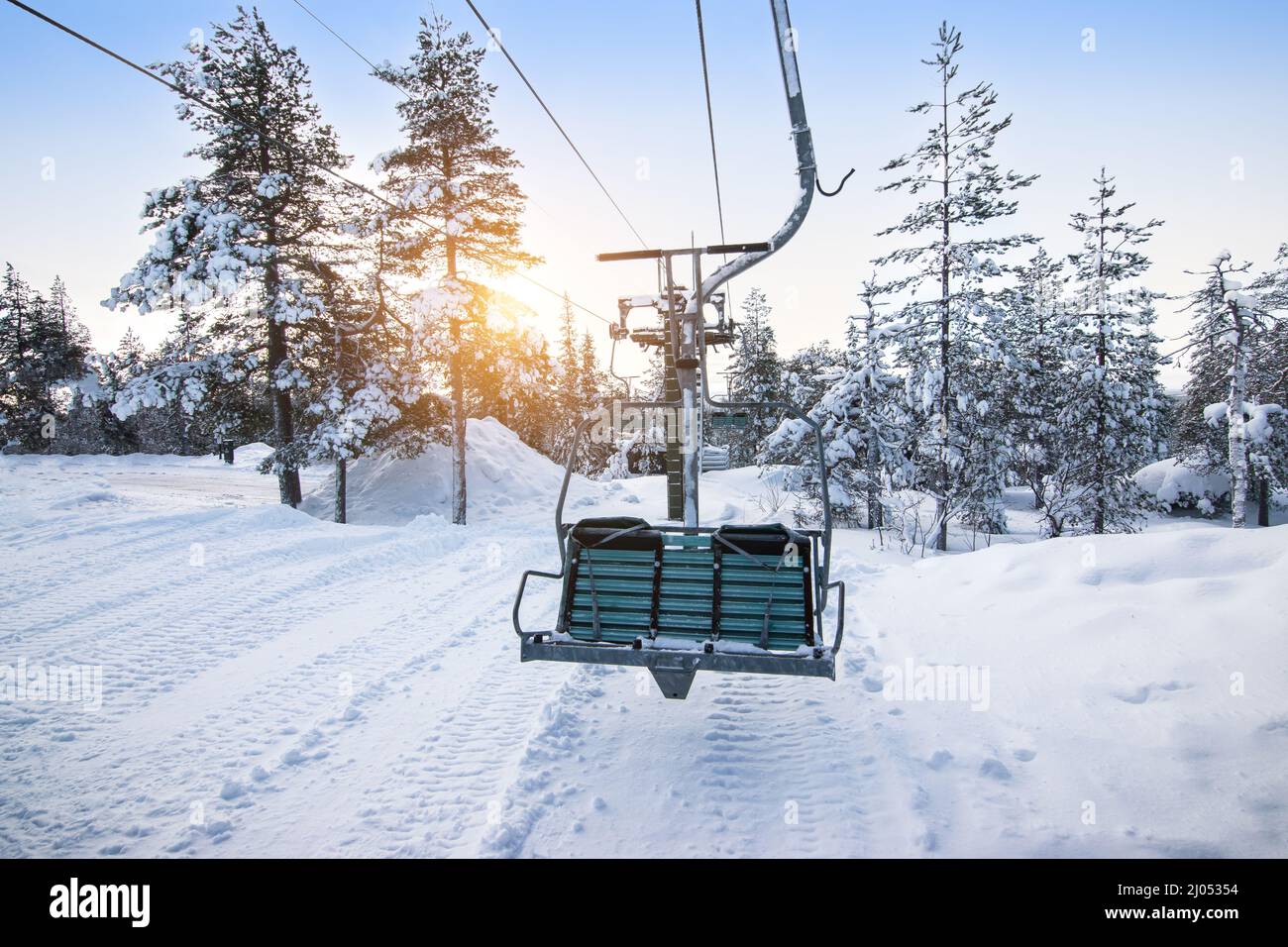 Ski lift at sunrise in the beautiful snowy nature of Lapland. Stock Photo