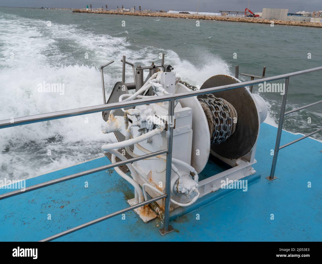 Closeup of a boat anchor winch pulley rope and a chain on a wavy