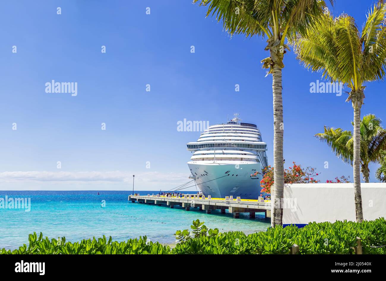 Cruise ship docked at tropical port on sunny day Stock Photo