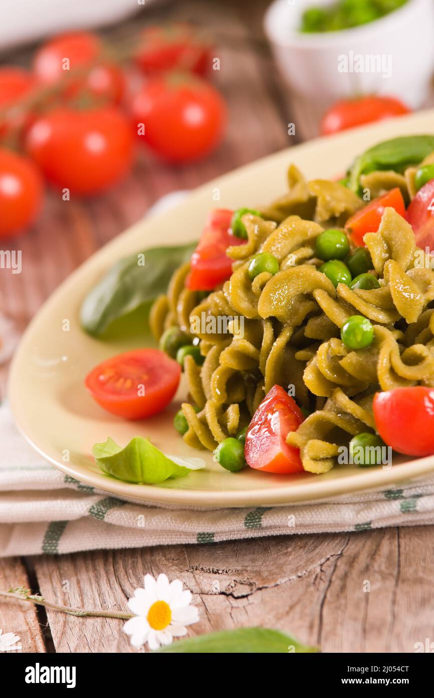 Fusilli pasta with cherry tomatoes and peas Stock Photo - Alamy