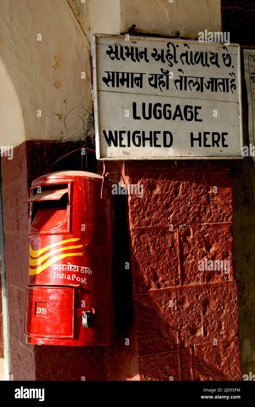 India Sep 30; 2009 Close up of Traditional red color old Indian mailbox or postbox Letter box and manual luggage weighing machine or scales at Amreli. Stock Photo