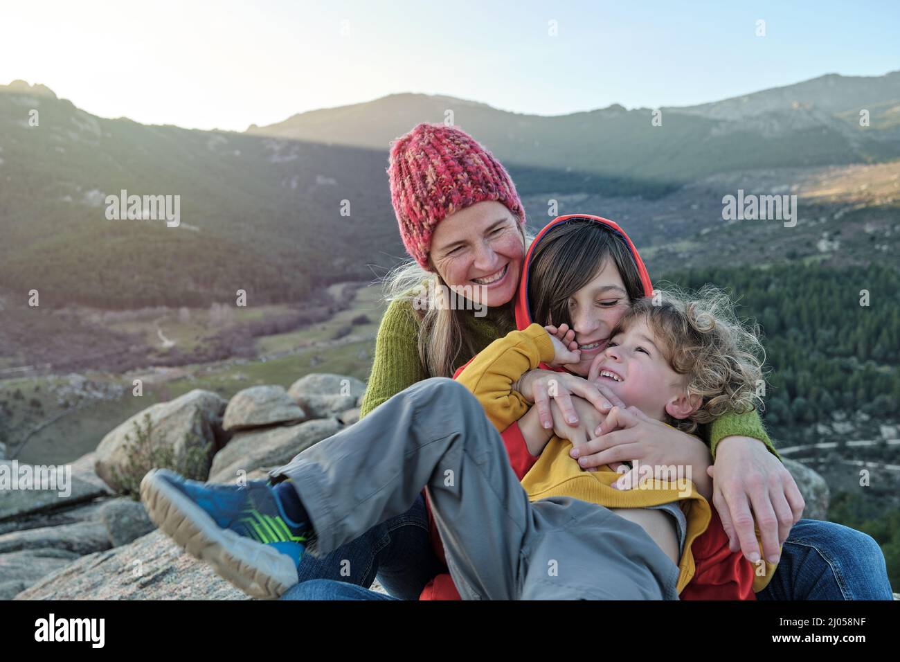 Mother plays with children as they relax in nature Stock Photo