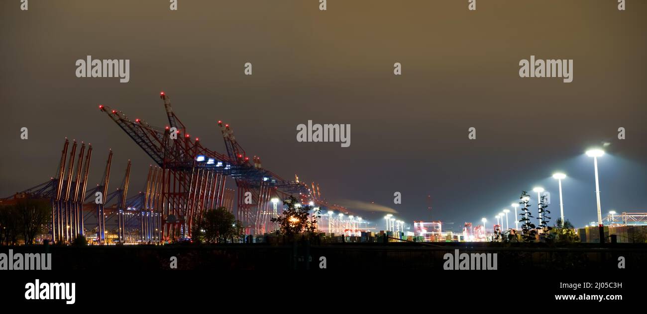 Container ships in the port of Hamburg at night Stock Photo