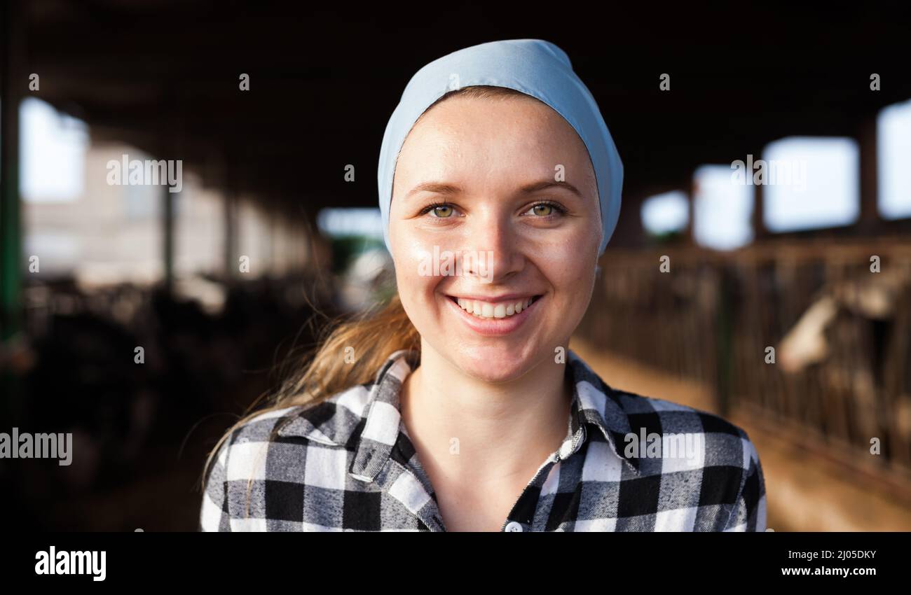 Positive female farmer posing in cowshed at dairy farm Stock Photo - Alamy
