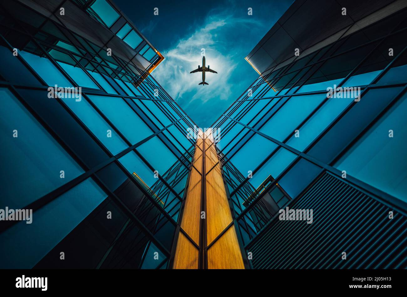 Low angle shot of airplane and skyscrapers on blue sky background for ...