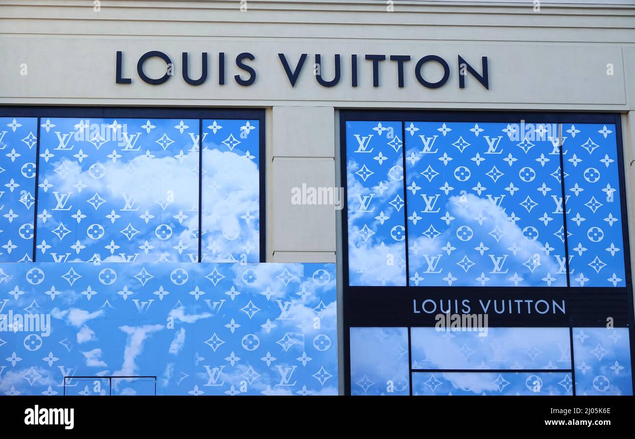 Premium Photo  Miami, usa - march 20, 2021: louis vuitton shop window with  cat asleep in banana skin and lv bag by urs fischer at night design  district in florida.
