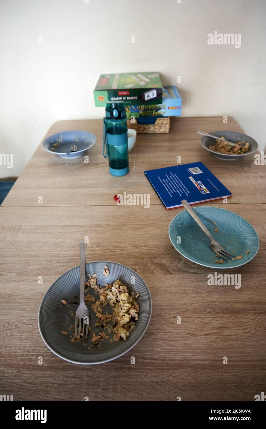 Vertical shot of a wooden table with plates and board games on top Stock Photo