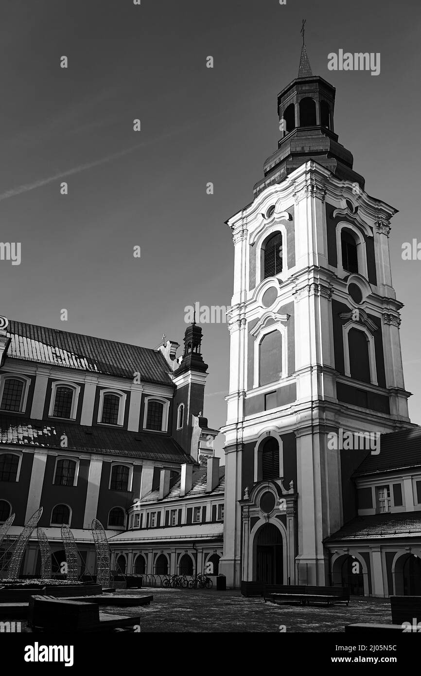 The courtyard and the historic belfry of the baroque monastic church in the city of Poznan, monochrome Stock Photo