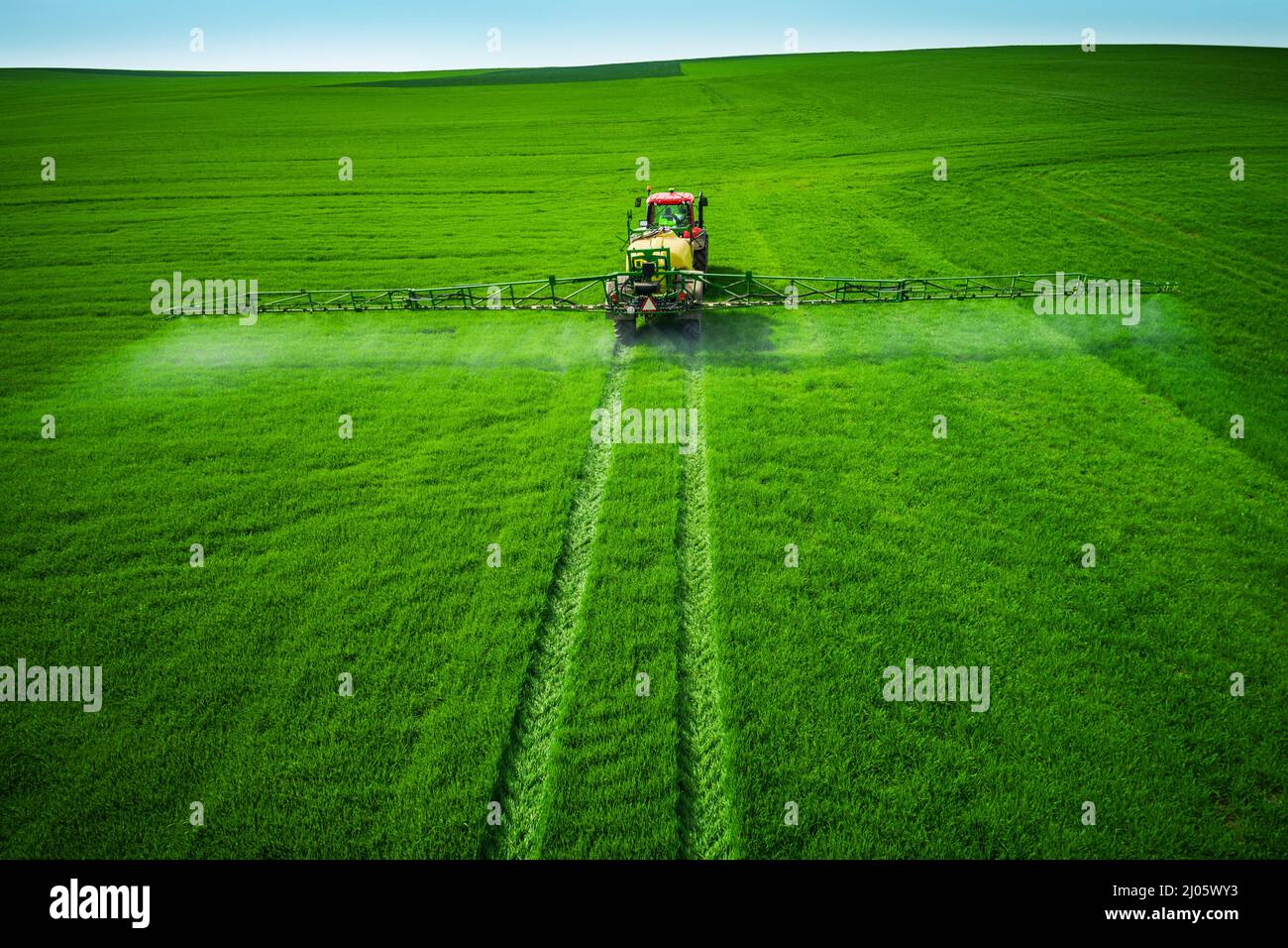 Aerial view of farming tractor plowing and spraying on field Stock ...