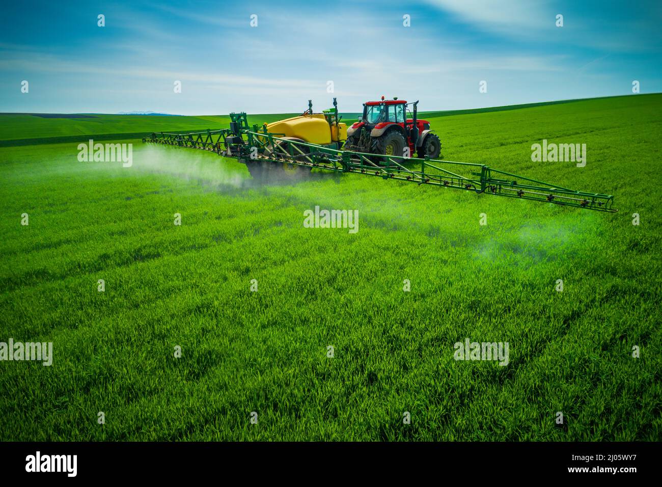 Aerial view of farming tractor plowing and spraying on field Stock ...