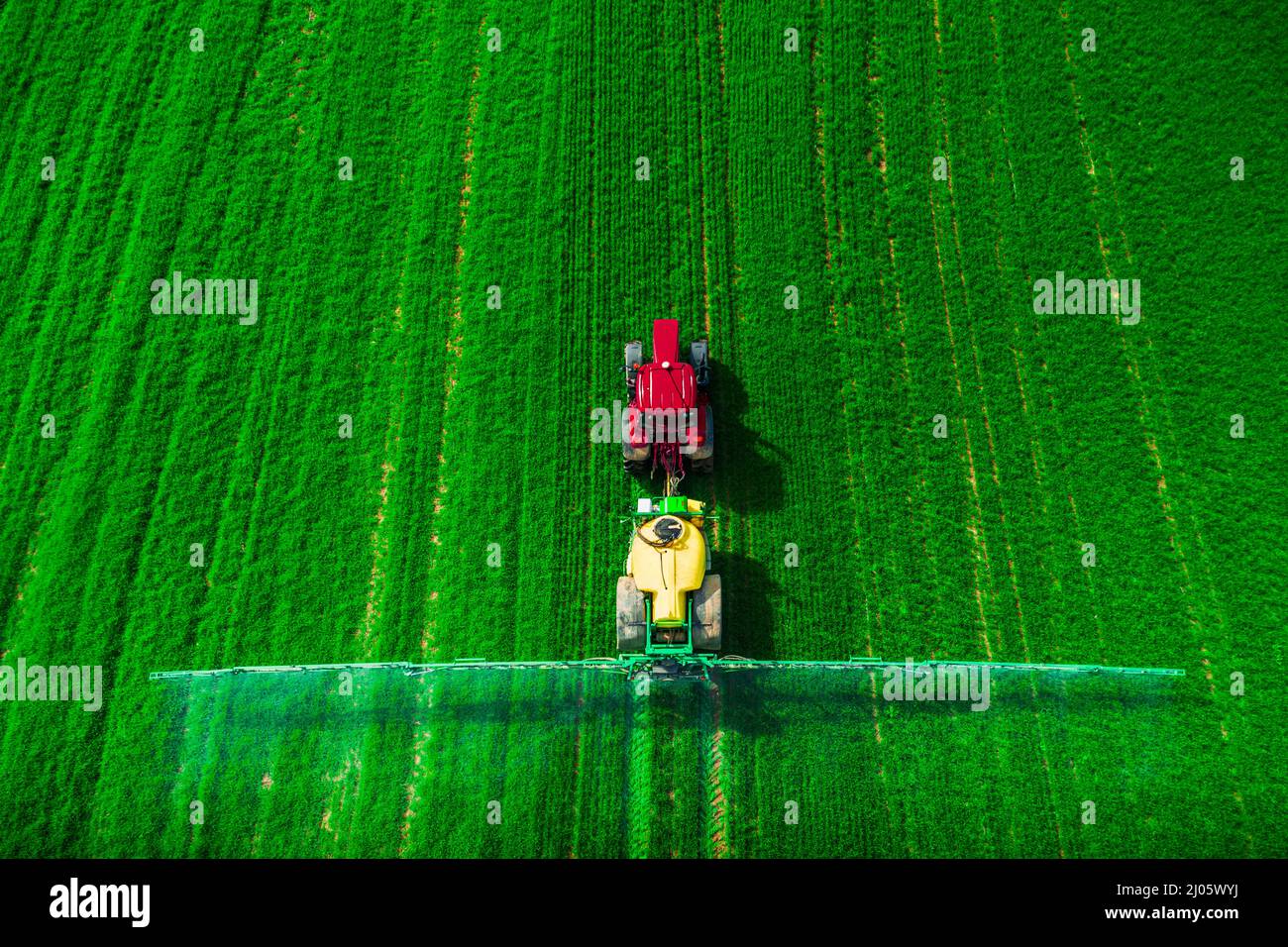 Aerial view of farming tractor plowing and spraying on field Stock ...