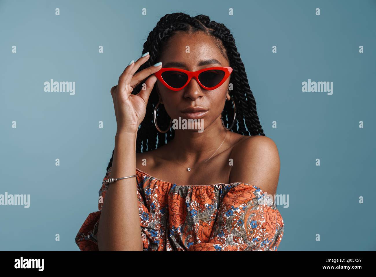 Young black woman in sunglasses posing and looking at camera isolated ...
