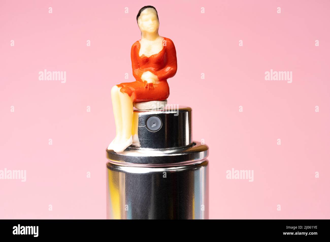a statuette of a woman sitting on a perfume bottle Stock Photo