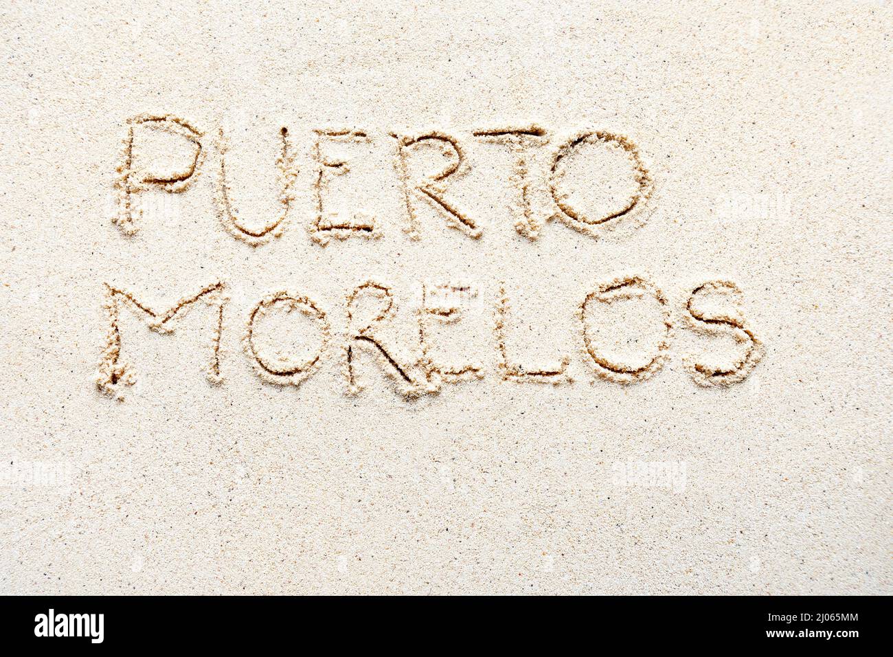 Handwriting words 'Puerto Morelos' on sand of beach Stock Photo