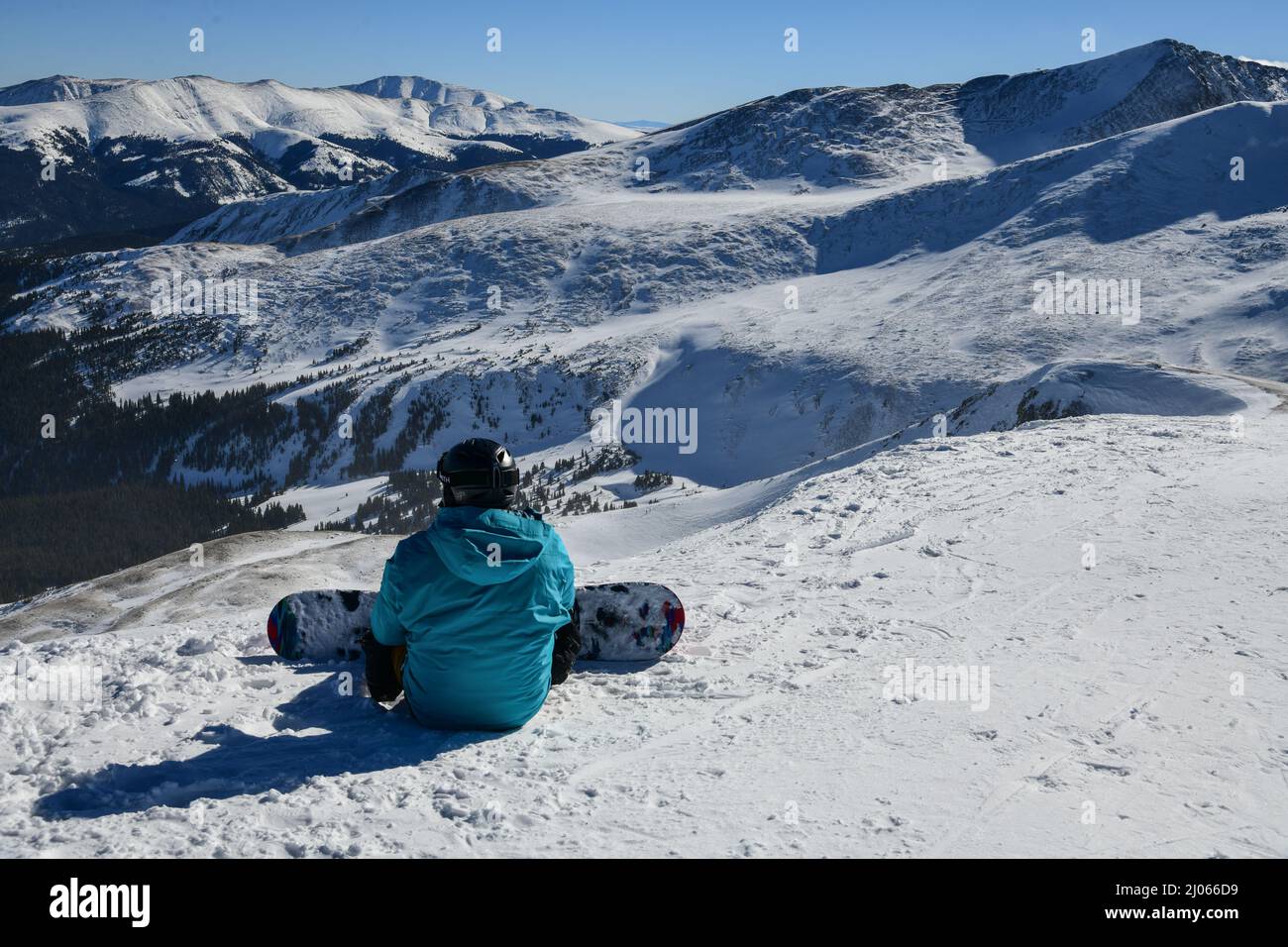 Snowboarder sitting on the top of Peak 8 at the Breckenridge Ski Resort in Colorado. Active lifestyle, extreme winter sports. Stock Photo
