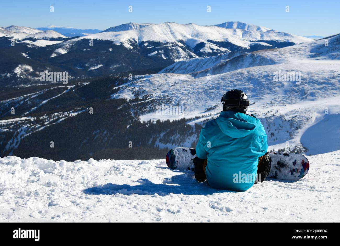 Snowboarder sitting on the top of Peak 8 at the Breckenridge Ski Resort in Colorado. Active lifestyle, extreme winter sports. Stock Photo