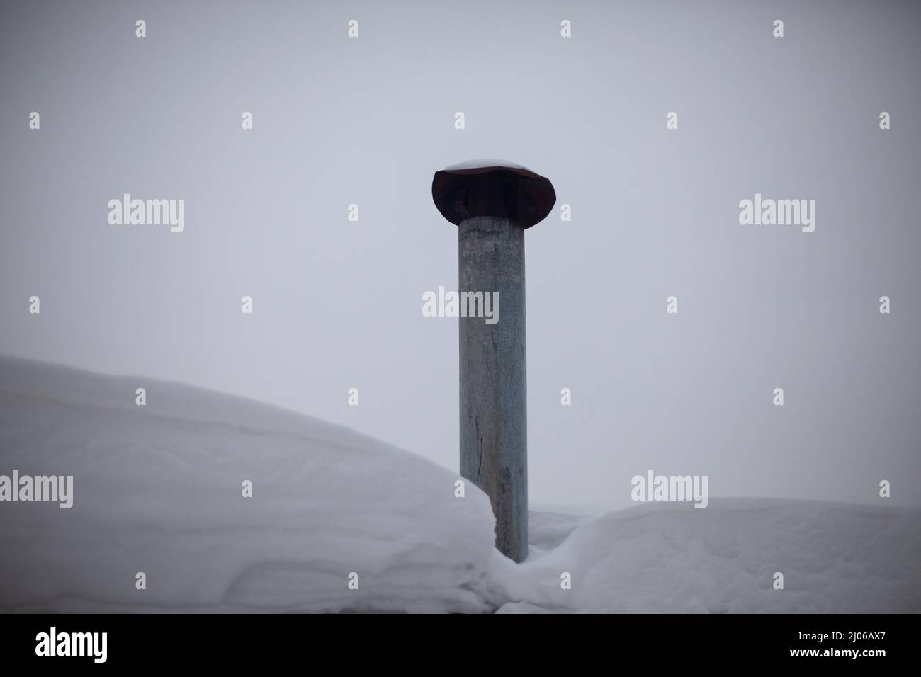 Chimney on roof. Stainless steel heat dissipation pipe. Chimney from furnace. Snowy weather outside. Stock Photo