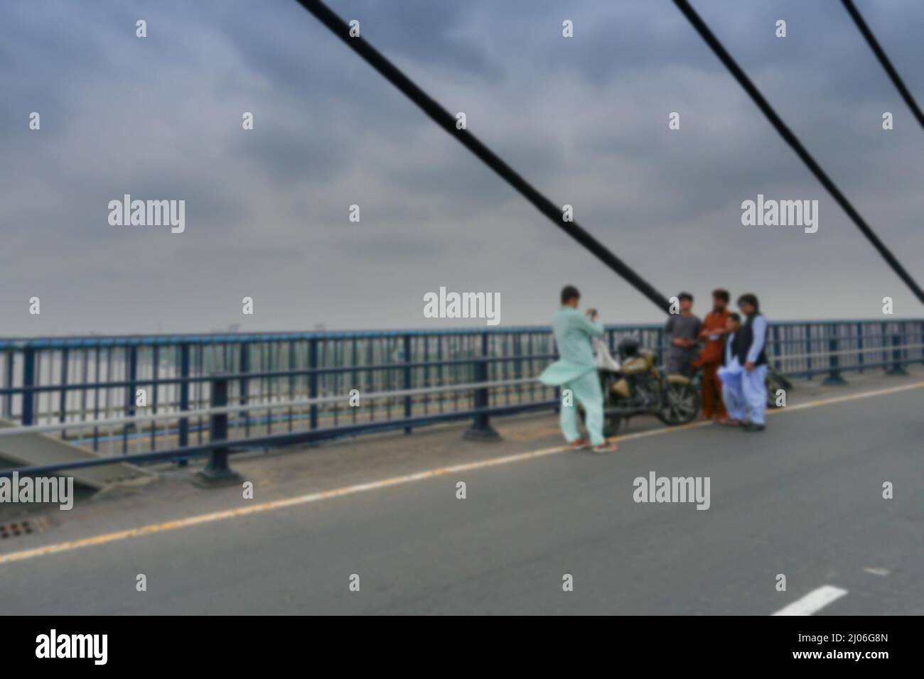 Blurred image of Kolkata, West Bengal, India. Young Muslim men taking picture of themselves on 2nd Hoogly Bridge. Stock Photo