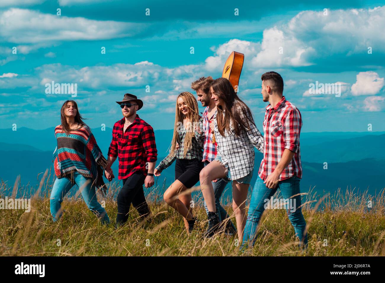 Young people on mountain hike. Group of friends go to mountains journey ...