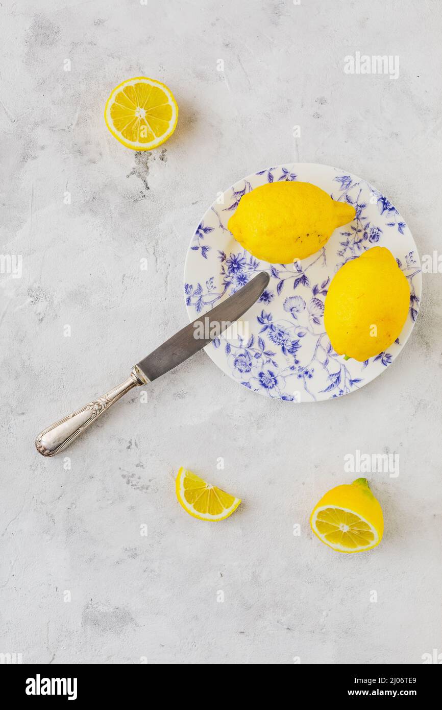 Vintage plate with lemons on vintage white background and vintage knife