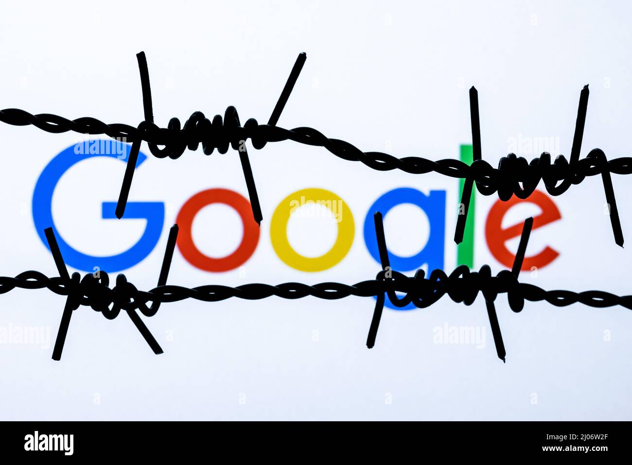 Google technology company logo behind barbed wire. The concept of Google censorship and prohibition. Stock Photo