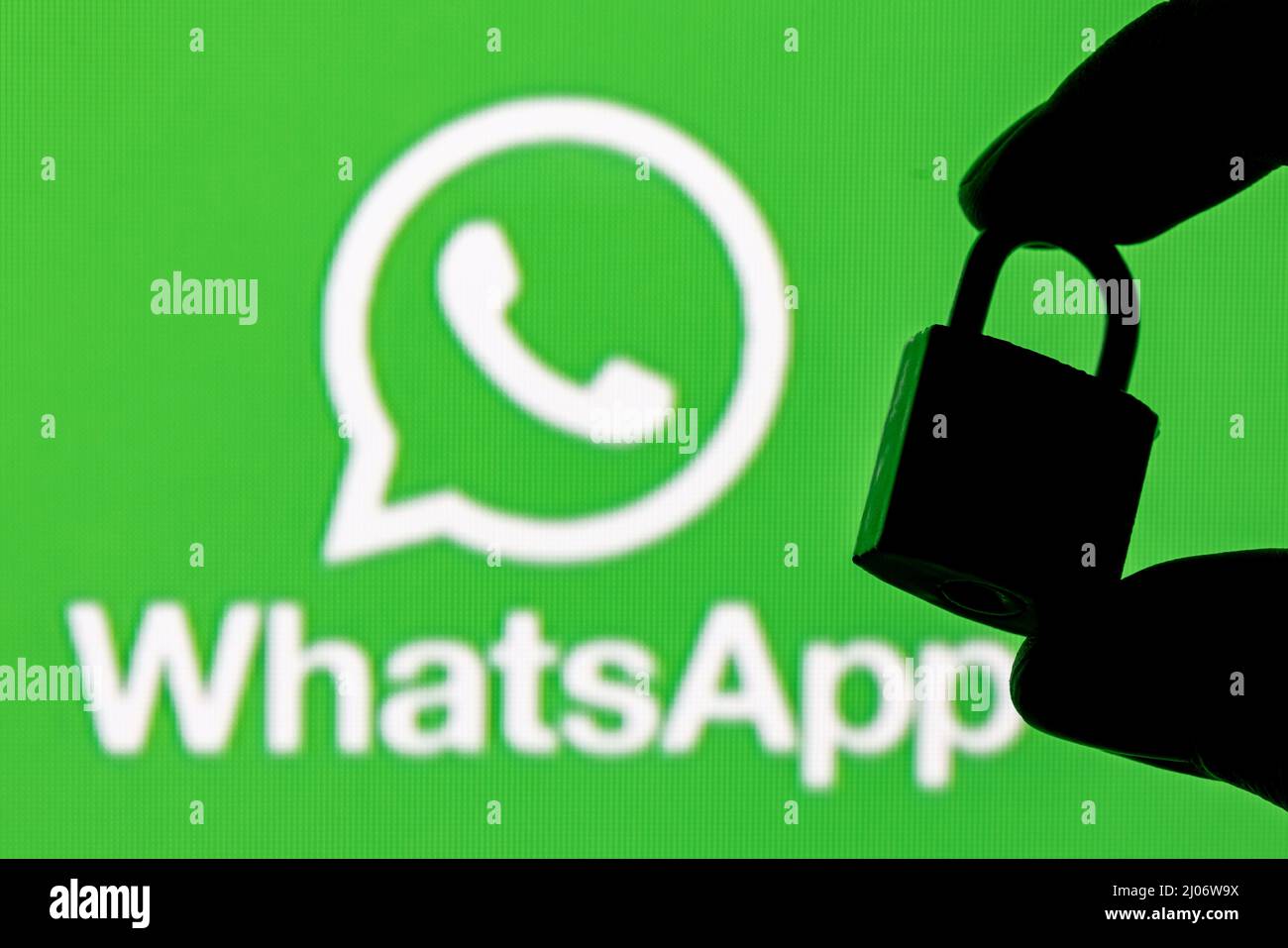 The icon of the Whatsapp messenger application among other applications on the smartphone screen. On the background is the Whatsapp logo. Stock Photo