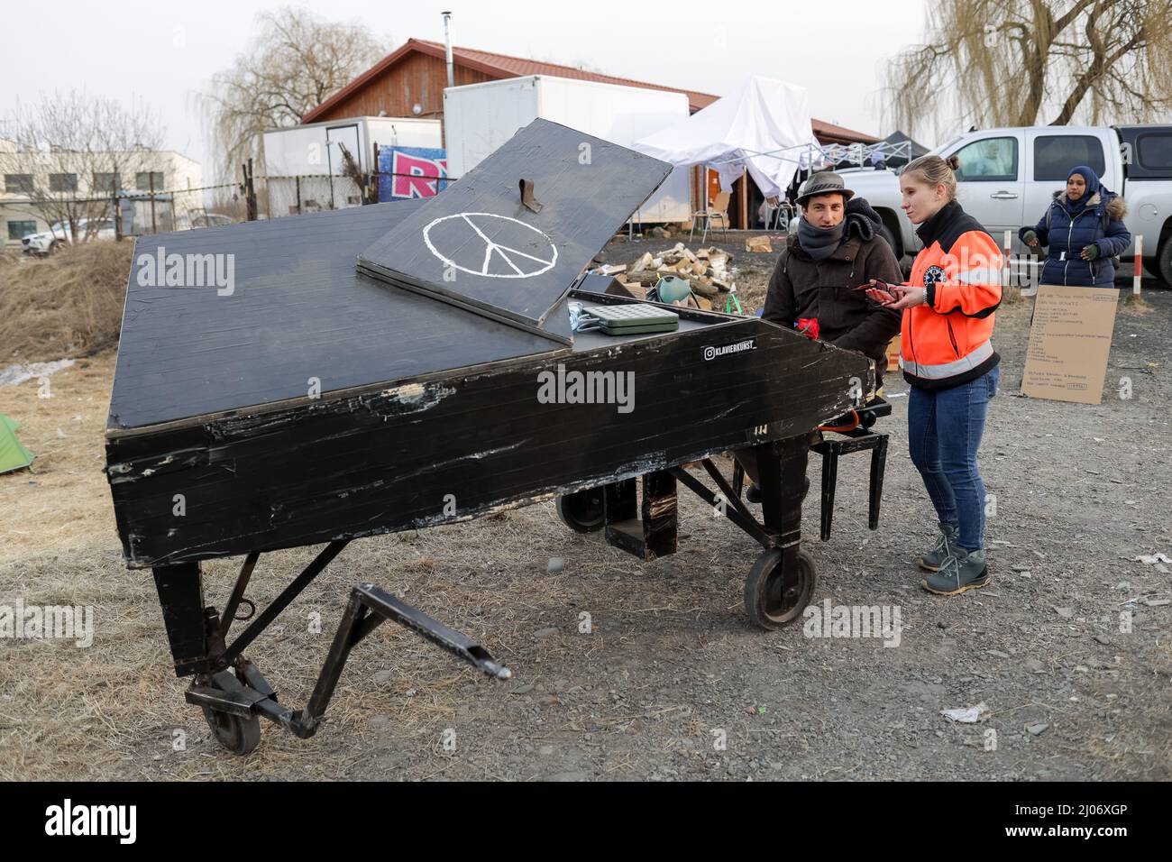 A man is seen ready to play the piano in the middle of the refugee cam hold at Medyka, Poland, on 16th of March 2022. Stock Photo