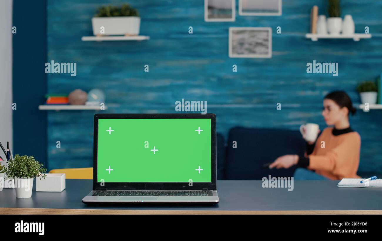Modern laptop with green screen template on desk at home, online school class with isolated copy space, blank mockup background and chroma key on display. Computer with technology. Stock Photo