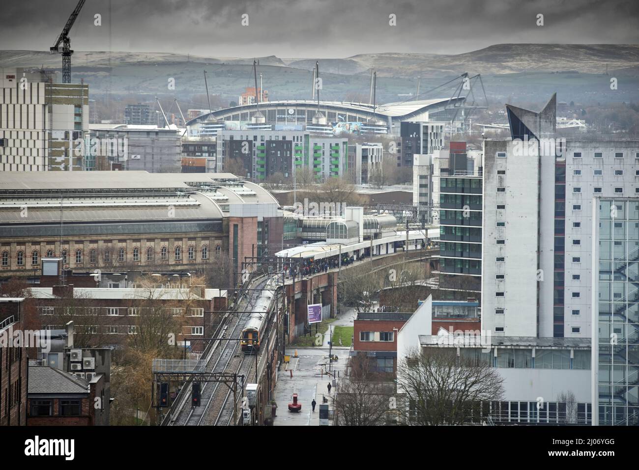 Trains at Manchester Piccadilly platforms 13 14, with Manchester City FC  Etihad stadium on the skyline Stock Photo - Alamy