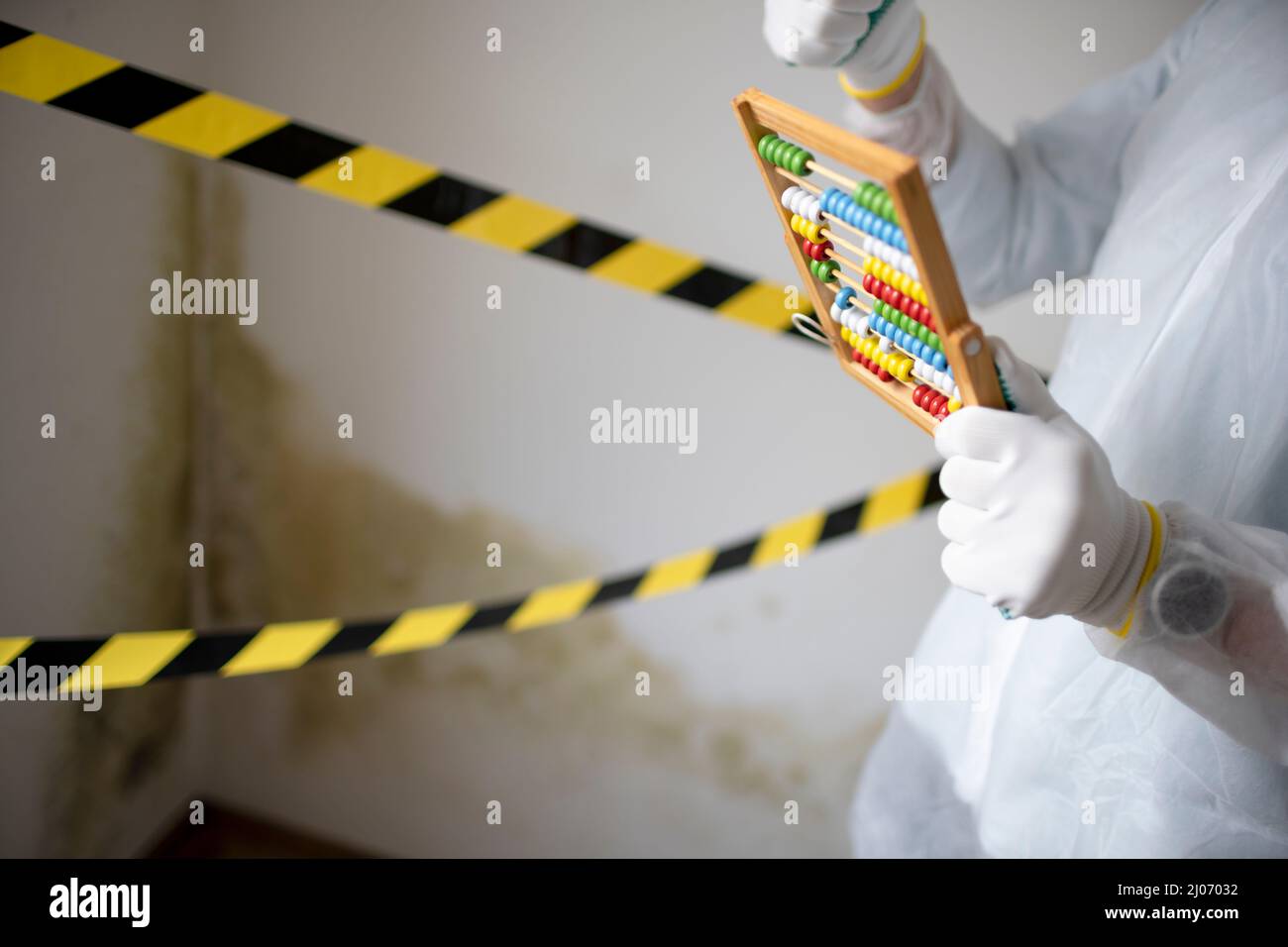 Man with white protective suit with abacus calculator, slide rule in hand  and mouth nose mask in front of yellow black barrier tape in front of wall  w Stock Photo - Alamy
