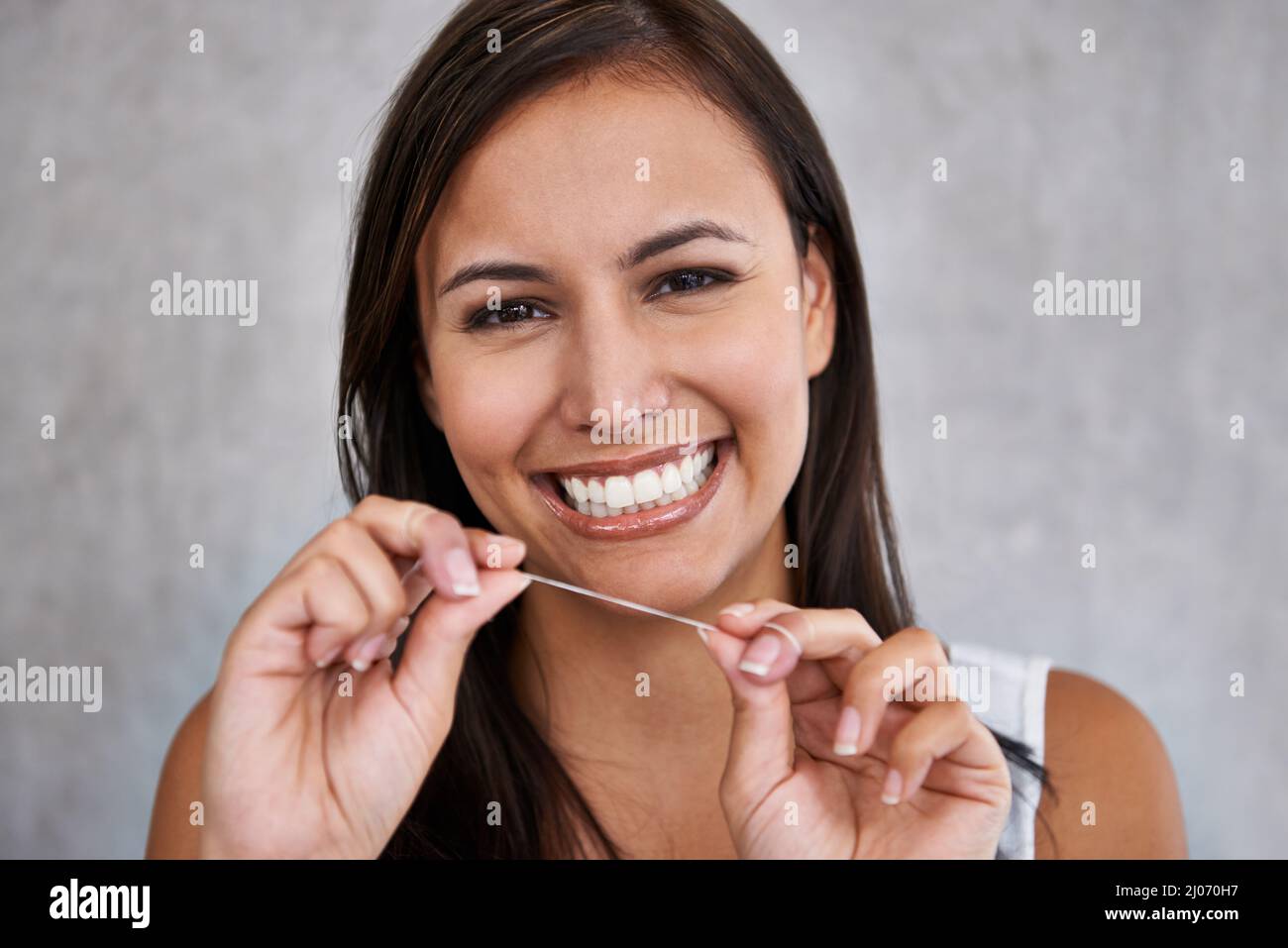 Only floss the teeth you want to keep. An isolated portrait of a young