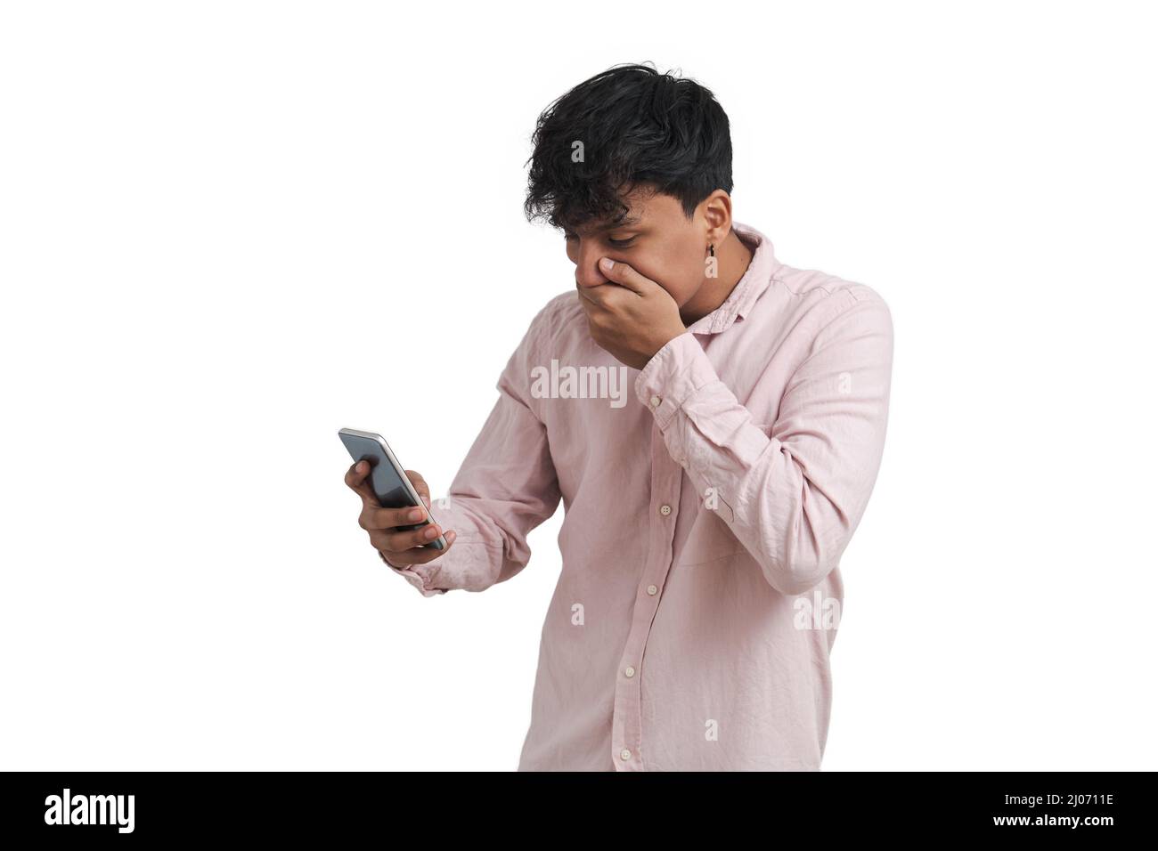 Young peruvian man surprised using the smartphone, isolated. Stock Photo