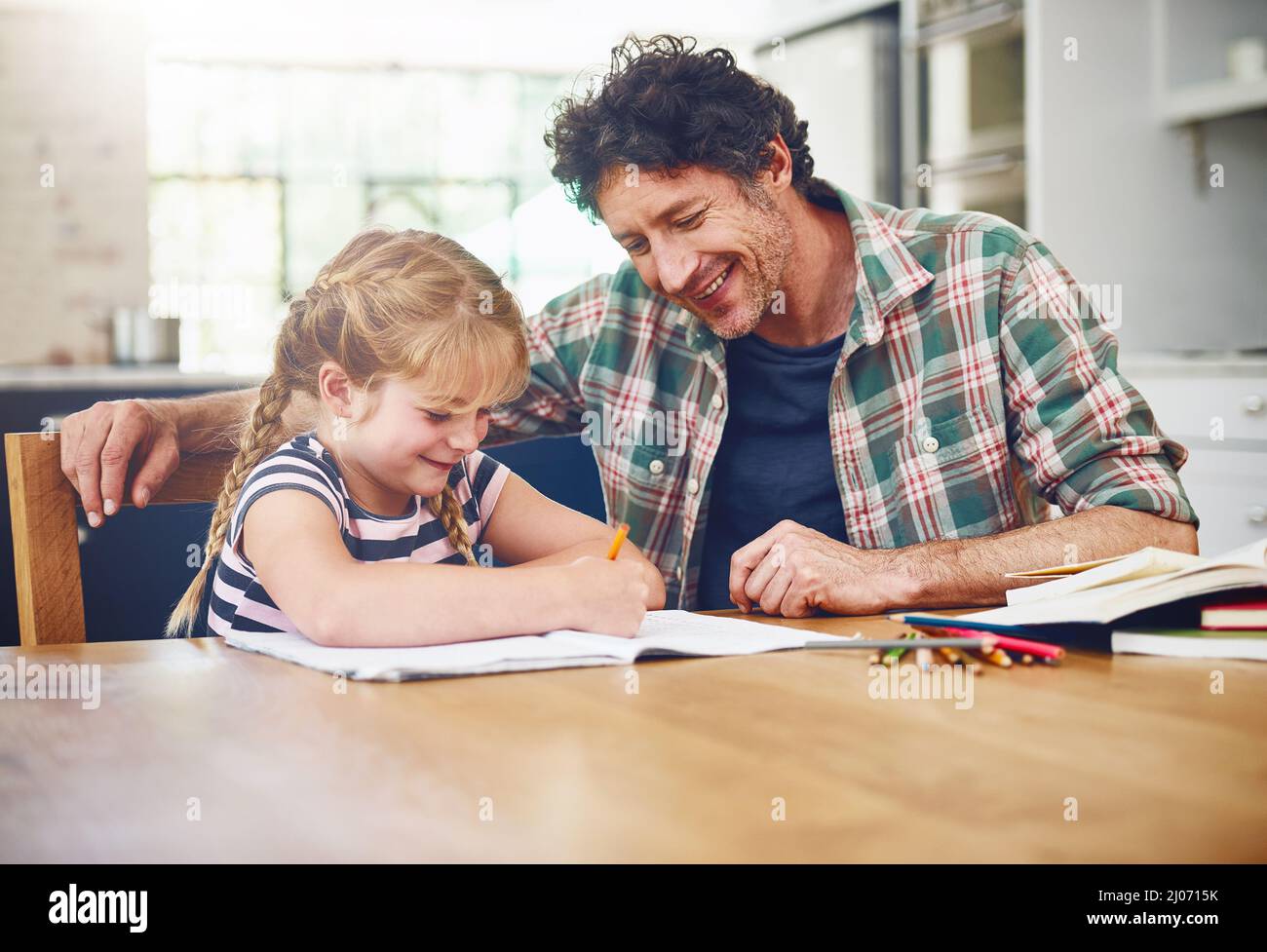 Its important to provide encouragement to kids. Cropped shot of a father helping his daughter with her homework. Stock Photo