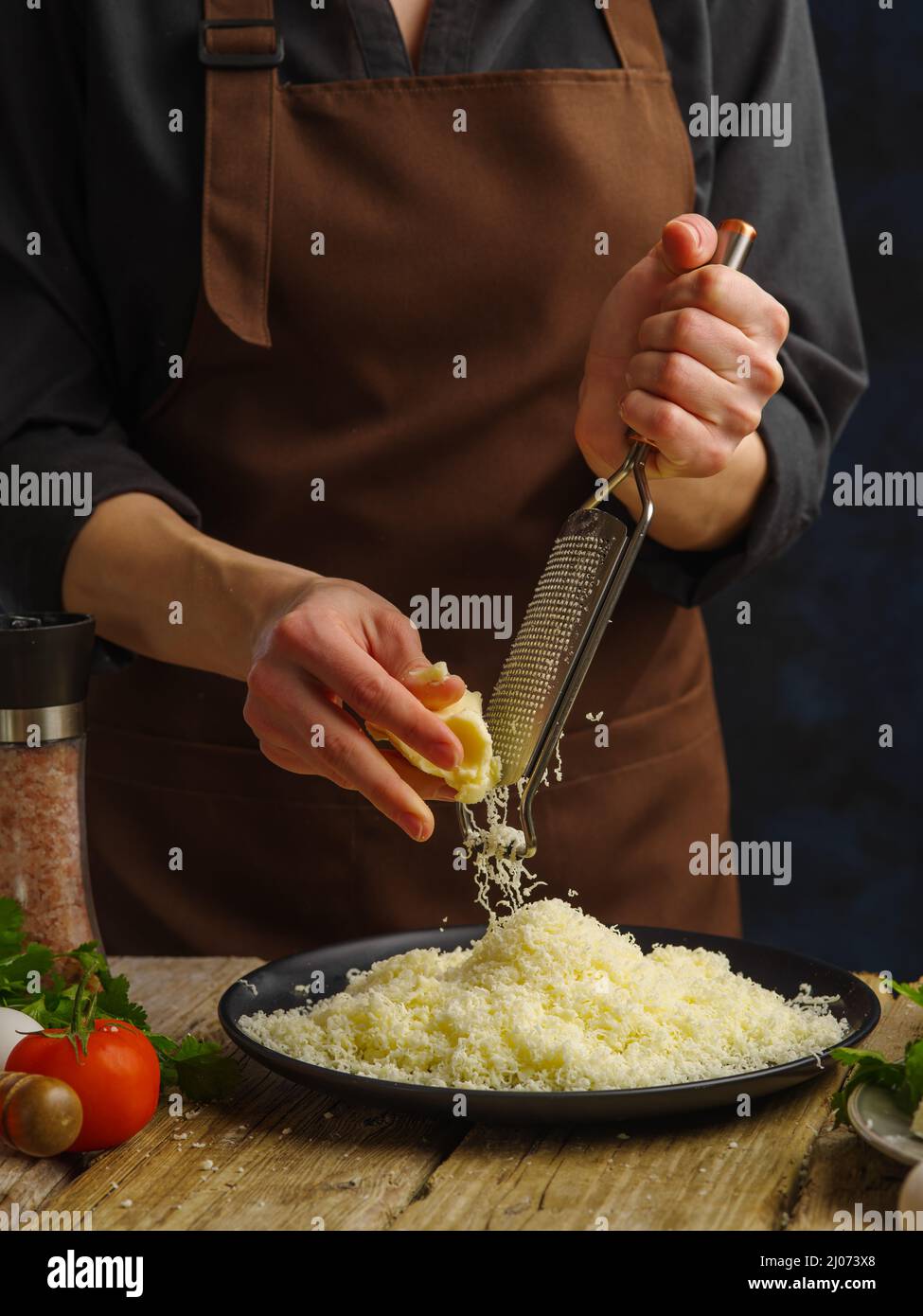 https://c8.alamy.com/comp/2J073X8/chef-rubs-cheese-mozzarella-for-preparation-of-salad-pizza-freezing-in-motionconcept-of-cooking-and-recipe-booksculinary-background-2J073X8.jpg
