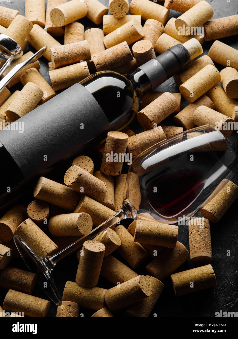 Black bottle of red wine with blank label for text with glass of red wine on background of traffic jams.Background and screensaver, banner for adverti Stock Photo
