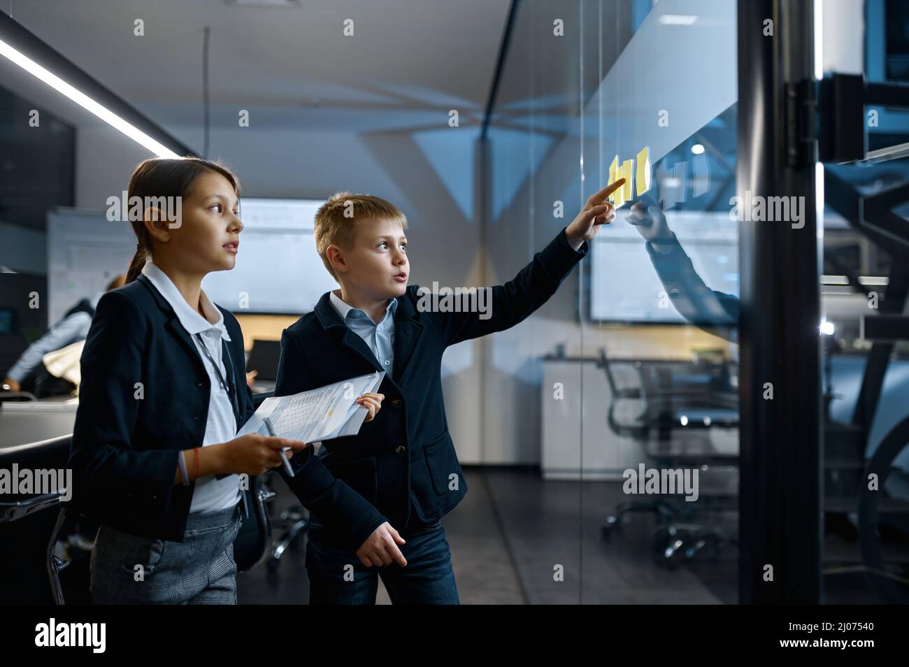 Focused children teammates working together near board Stock Photo