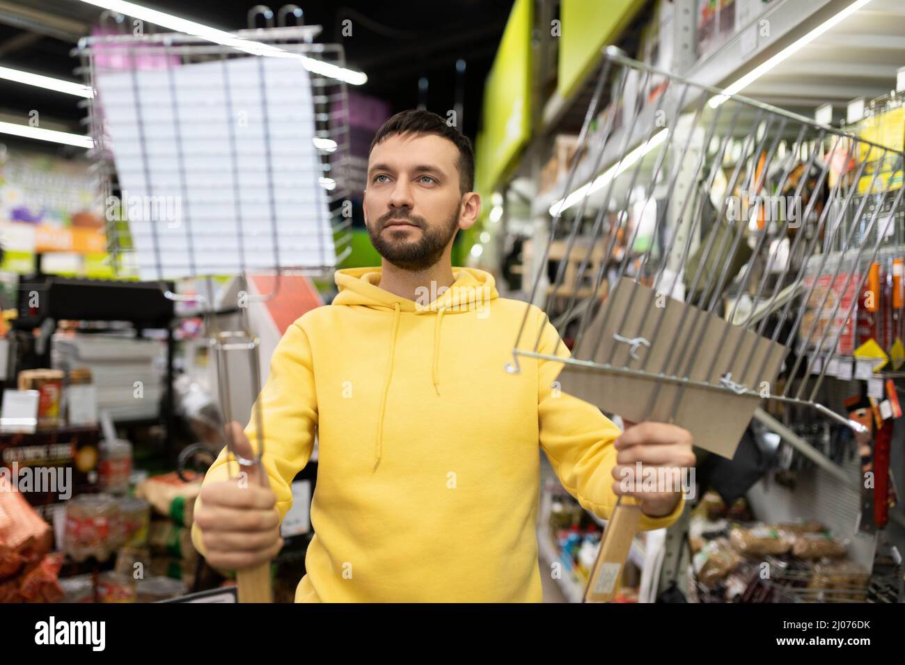 a man chooses a new grate for grilling and barbecue Stock Photo Alamy