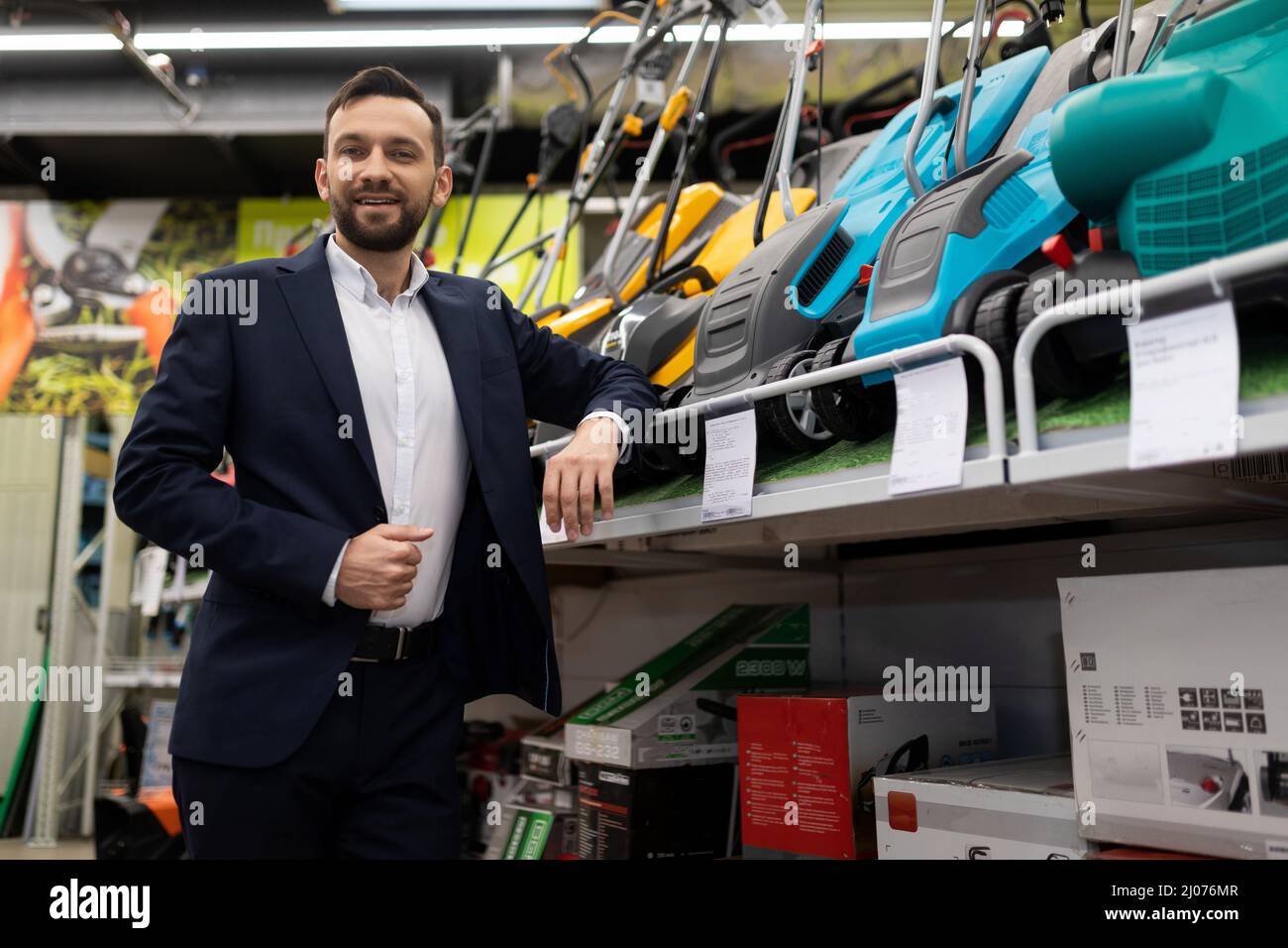 entrepreneur businessman store owner power tools for gardening next to