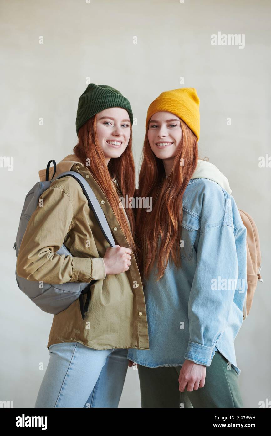 Vertical medium long studio portrait of two redhaired young Caucasian