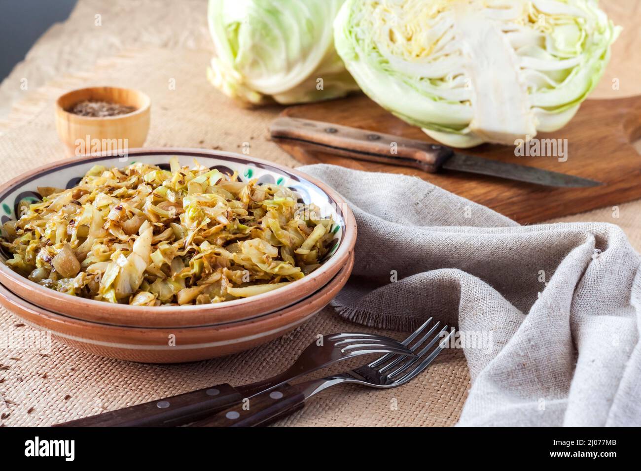 Fried white cabbage with caraway seeds and curry powder on rustic plate Stock Photo