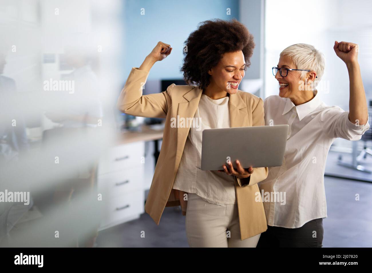 Happy multiethnic business women working together online on a laptop in ...