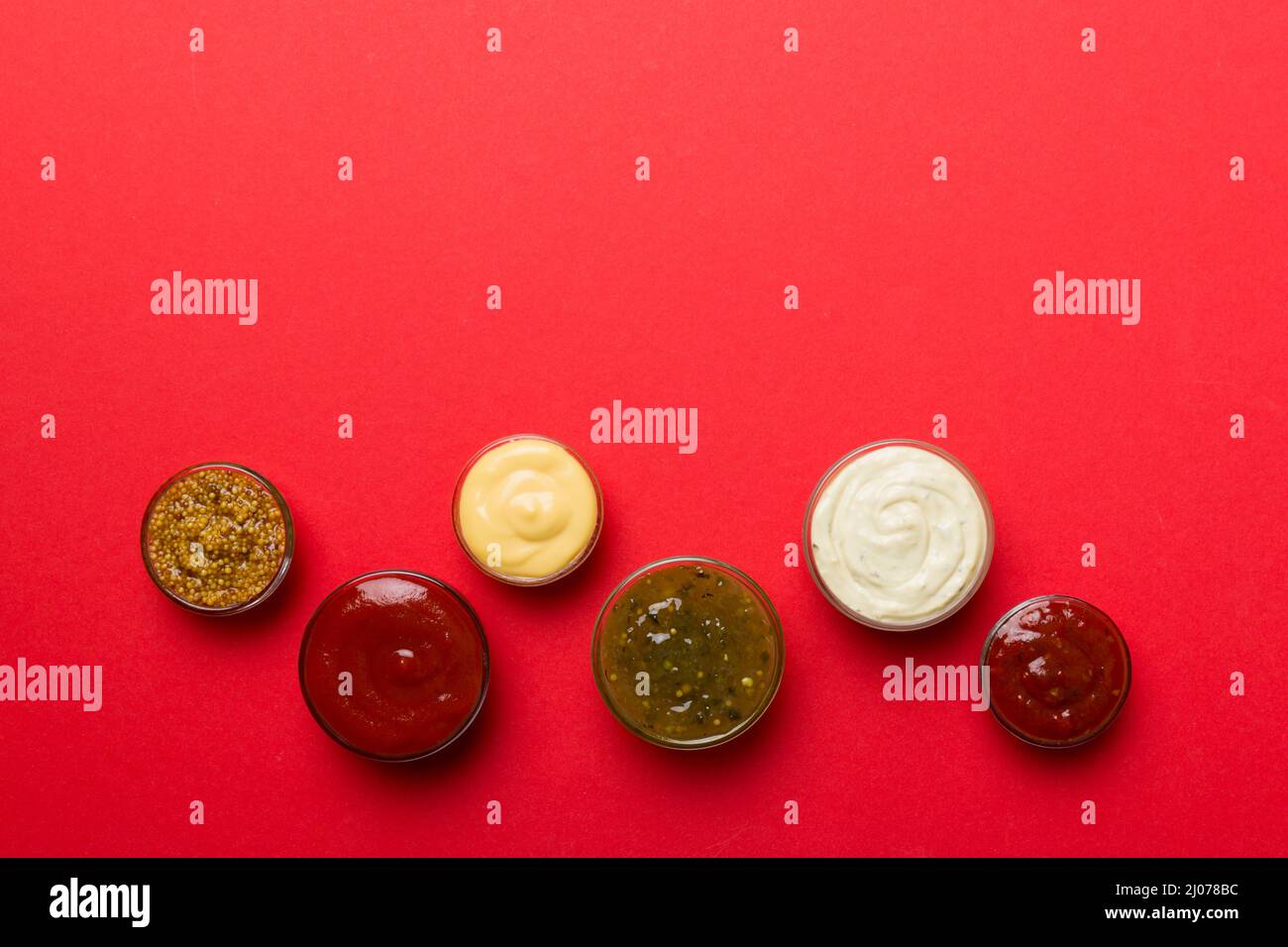 Different Types Of Sauces In Bowls On A Colored Board Top View